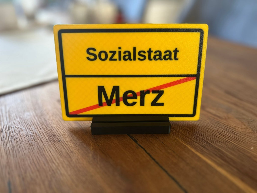 Ortsausgangsschild „Sozialstaat / Merz“ mit Standfuß - Subthiel - Marco Thiel