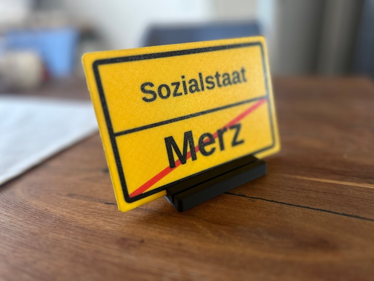 Ortsausgangsschild „Sozialstaat / Merz“ mit Standfuß - Subthiel - Marco Thiel