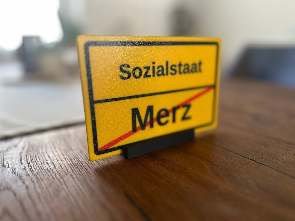 Ortsausgangsschild „Sozialstaat / Merz“ mit Standfuß - Subthiel - Marco Thiel