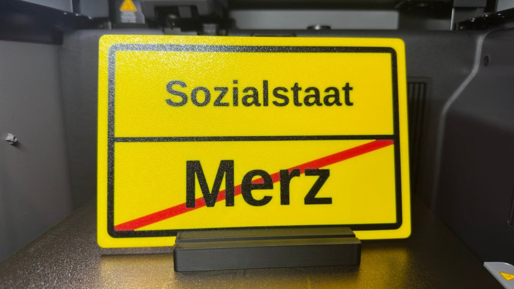 Ortsausgangsschild „Sozialstaat / Merz“ mit Standfuß - Subthiel - Marco Thiel